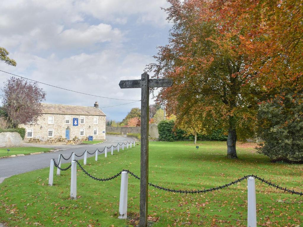 a wooden pole with a chain on the side of a road at 3 The Reading Room Cottages - Uk31802 in Barningham