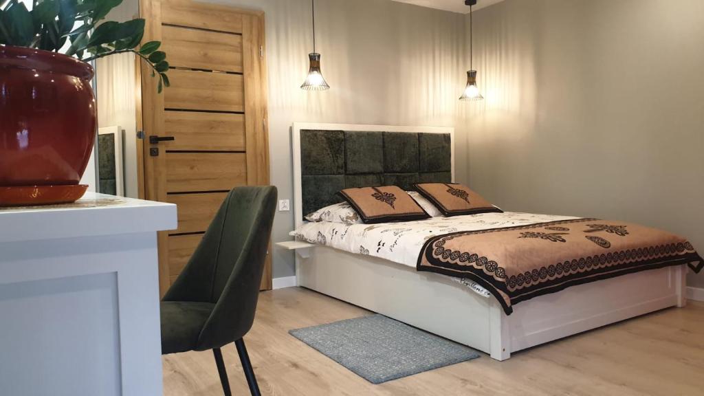 シュツァブニツァにあるGOLD apartamenty & spaのベッドルーム1室(ベッド1台、椅子、テーブル付)