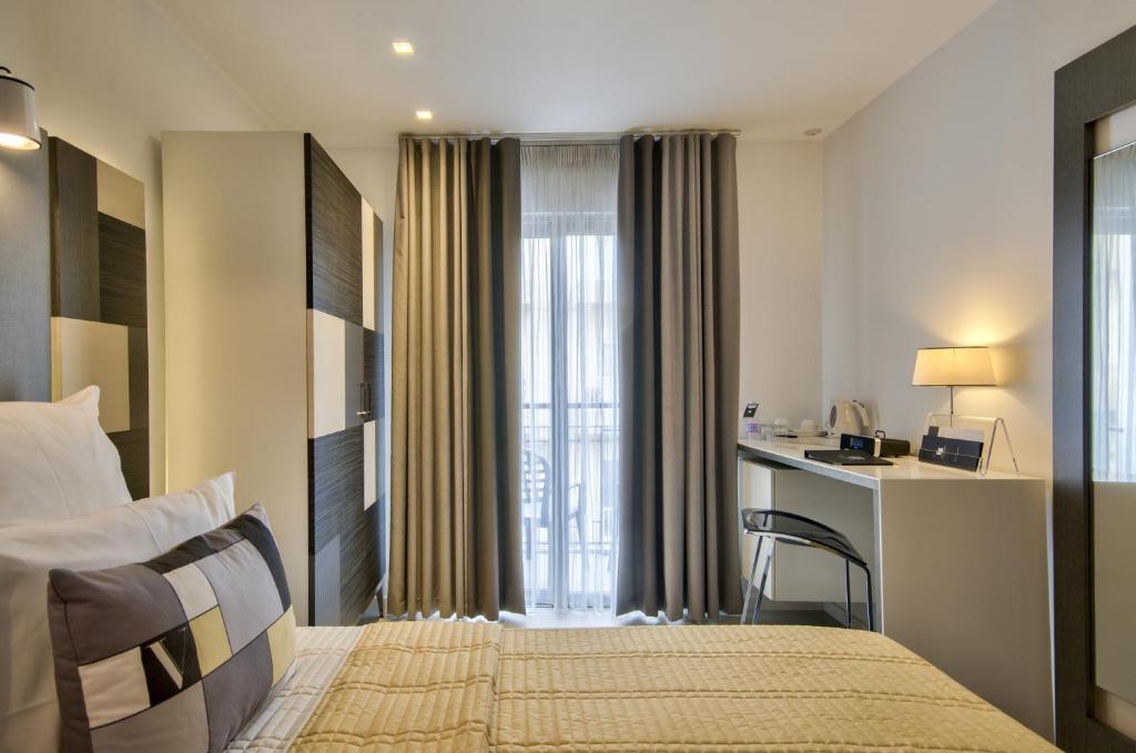 a hotel room with a bed and a desk with a computer at Hotel Valentina in St. Julianʼs