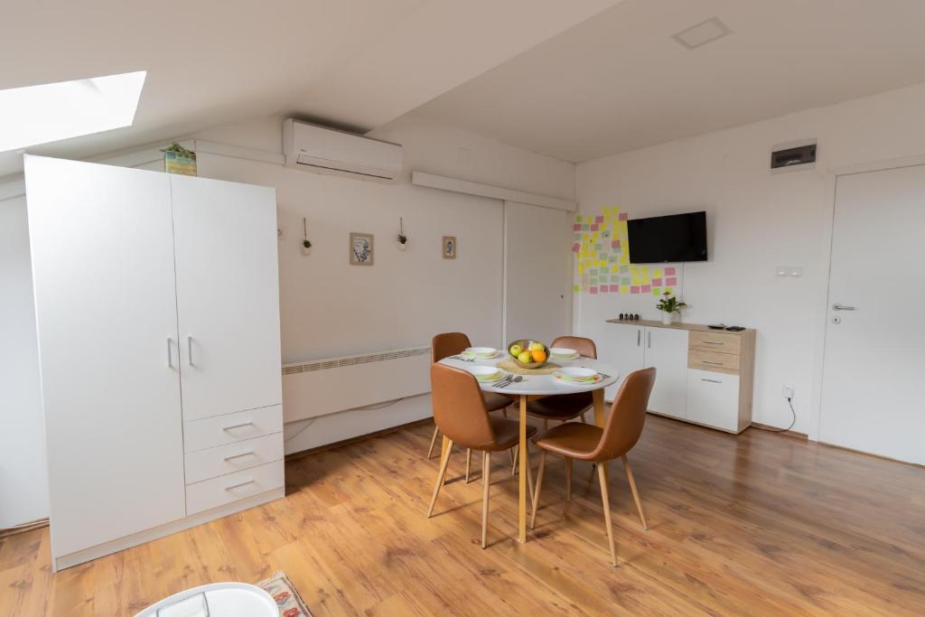 a kitchen and dining room with a table and chairs at Hill apartman - MAKSIMIR Rebro in Zagreb