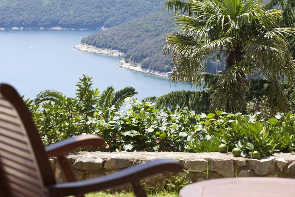 a bench sitting in front of a view of a lake at Casa M Rabac in Rabac