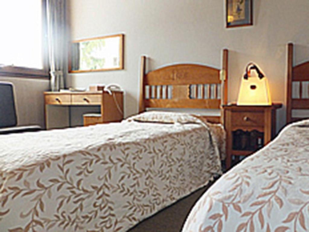 - une chambre avec 2 lits, une commode et un bureau dans l'établissement Zao Onsen Lodge Sukore - Vacation STAY 04093v, à Yamagata
