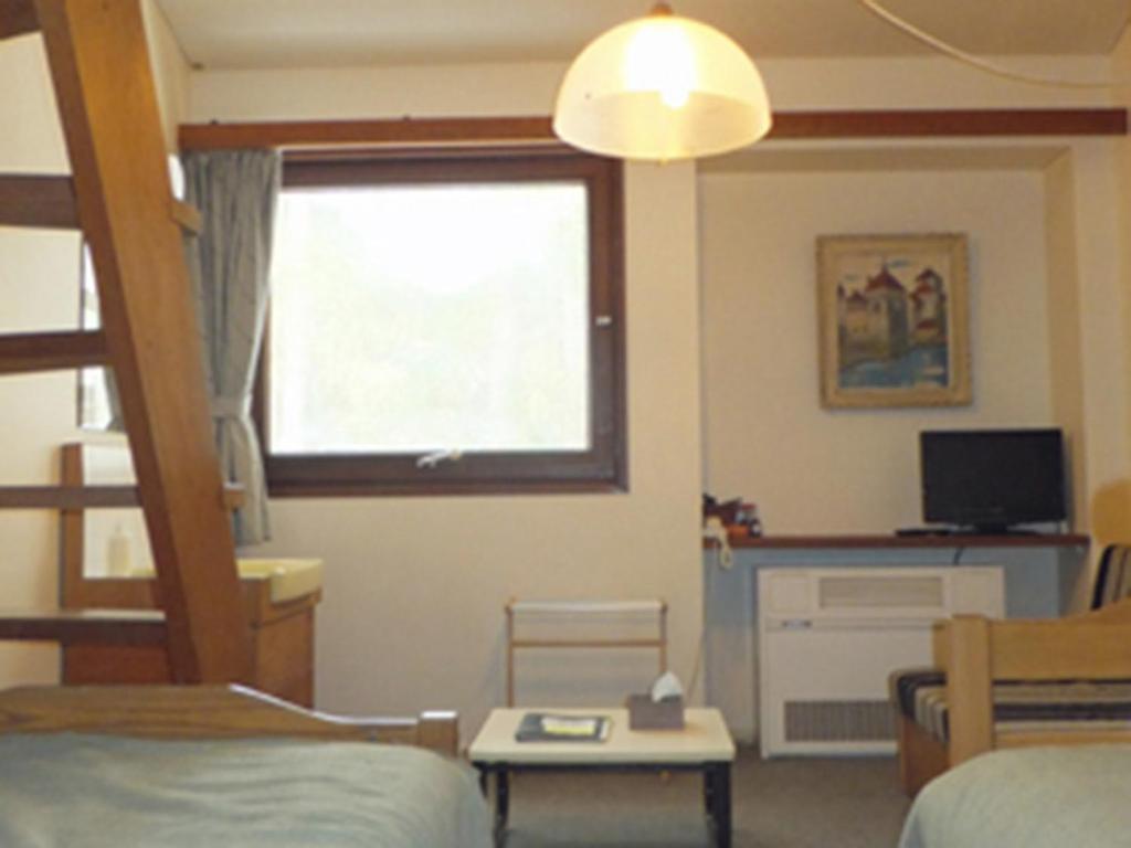 a room with a bed and a desk with a window at Zao Onsen Lodge Sukore - Vacation STAY 04418v in Yamagata