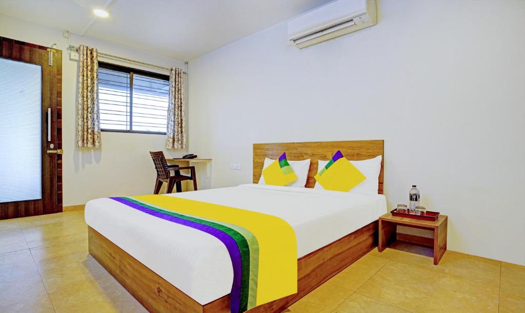 a bedroom with a large bed and a table at Itsy By Treebo - Oasis Pride in Nashik