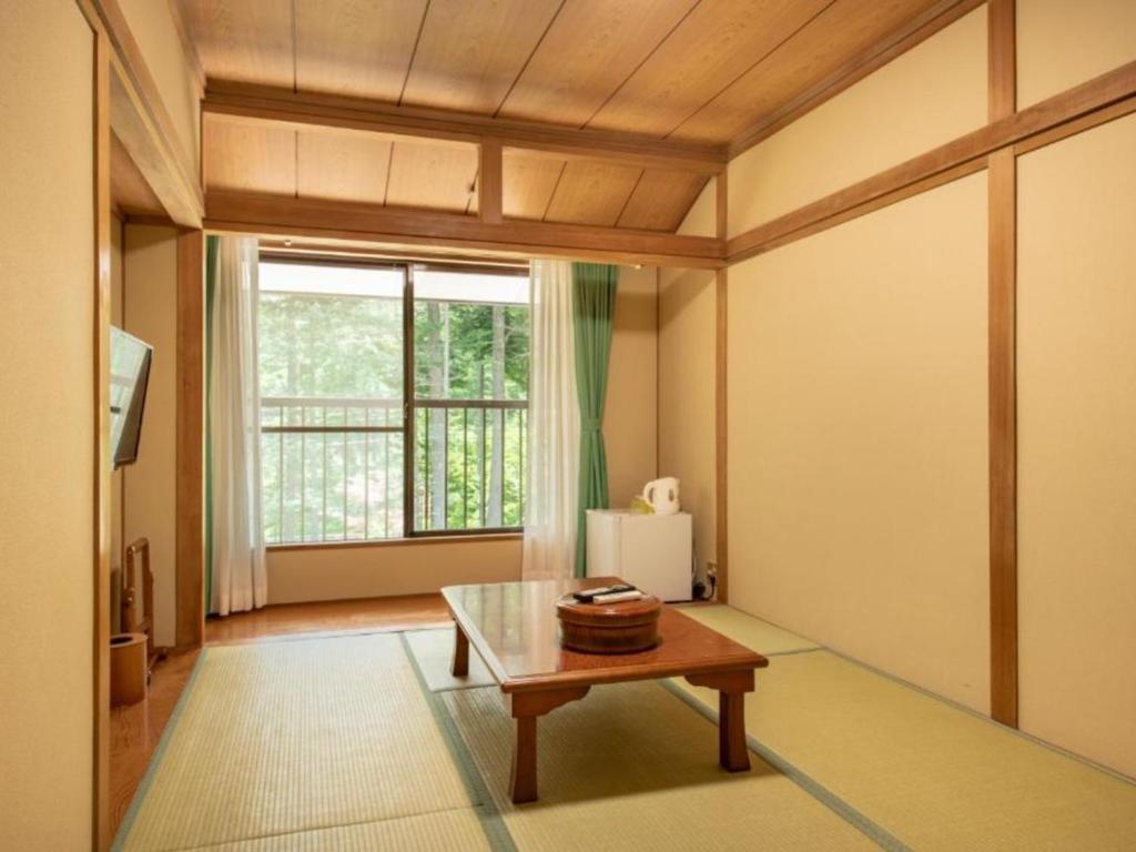 a living room with a table and a window at Yamanaka Lake ＲＹＯＺＡＮ - Vacation STAY 32152v in Yamanakako