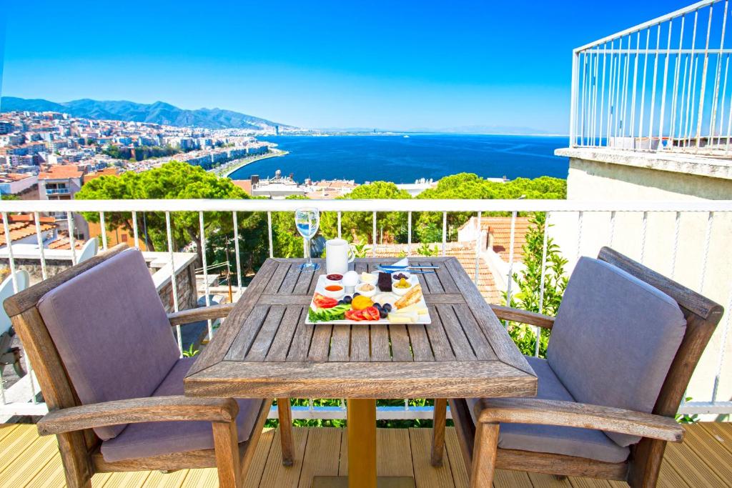 a wooden table with a plate of food on a balcony at Iconic Stone Houses in Izmir