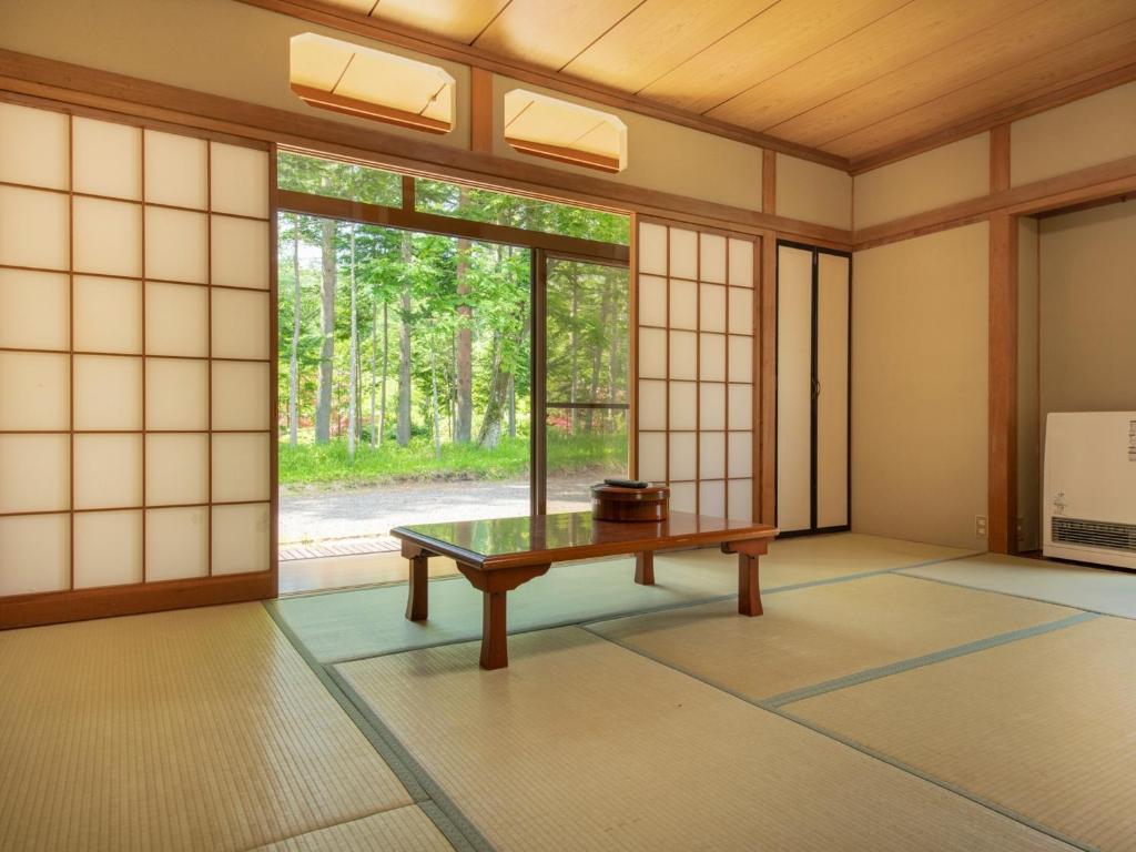 山中湖村にあるYamanaka Lake ＲＹＯＺＡＮ - Vacation STAY 32160vの窓際のテーブルが備わる空き部屋