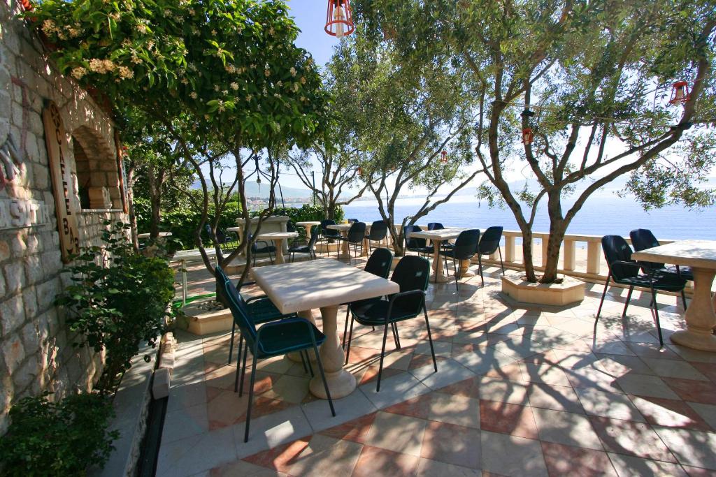 een patio met tafels en stoelen en het water bij Villa Segetski Dvori in Trogir
