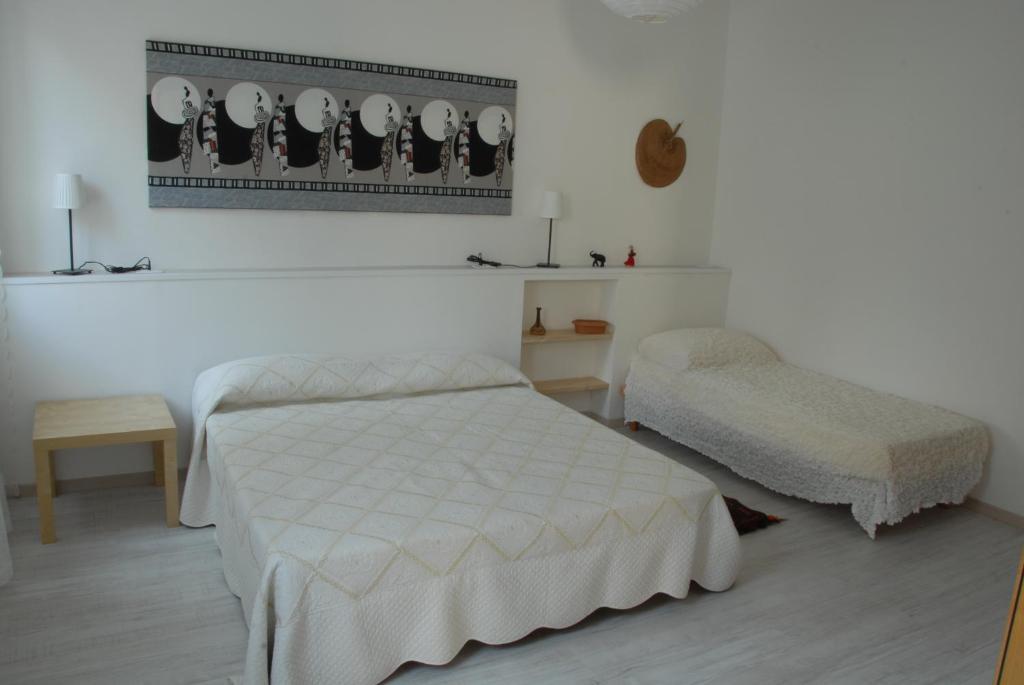a white bedroom with a bed and a chair at Da Irene in Mestre