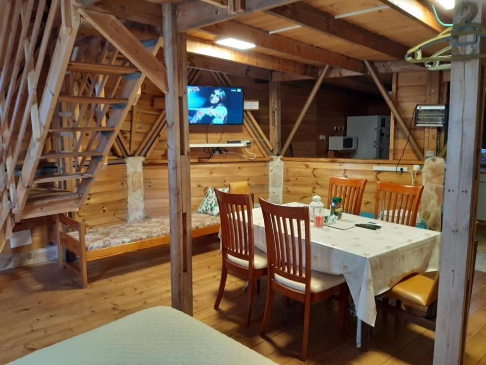 בקתת עץ בחורש במנות - דום גיאודזי - Wooden cabin in Manot في Manot: غرفة طعام مع طاولة وكراسي