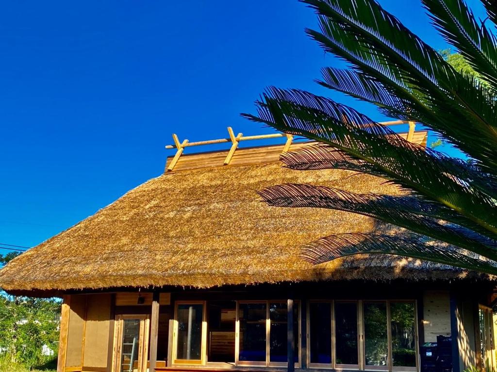 a thatch roof on a building with a palm tree at chigiterasu shintomi miyazaki - Vacation STAY 44990v in Saito