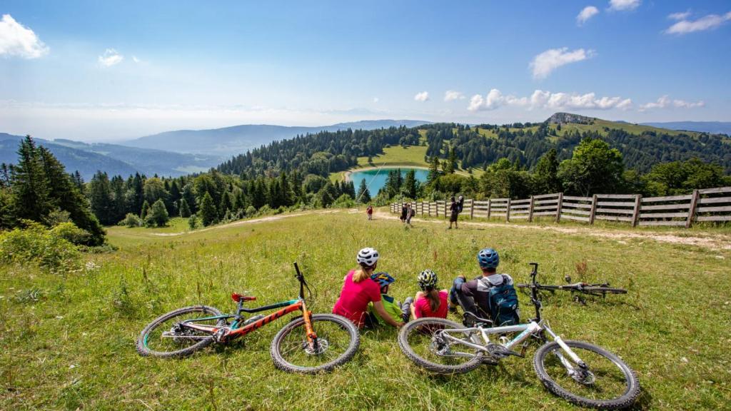 a group of people sitting on a hill with their bikes at Au-Doux-Altic chalet romantique avec JACUZZI ET SAUNA in Métabief