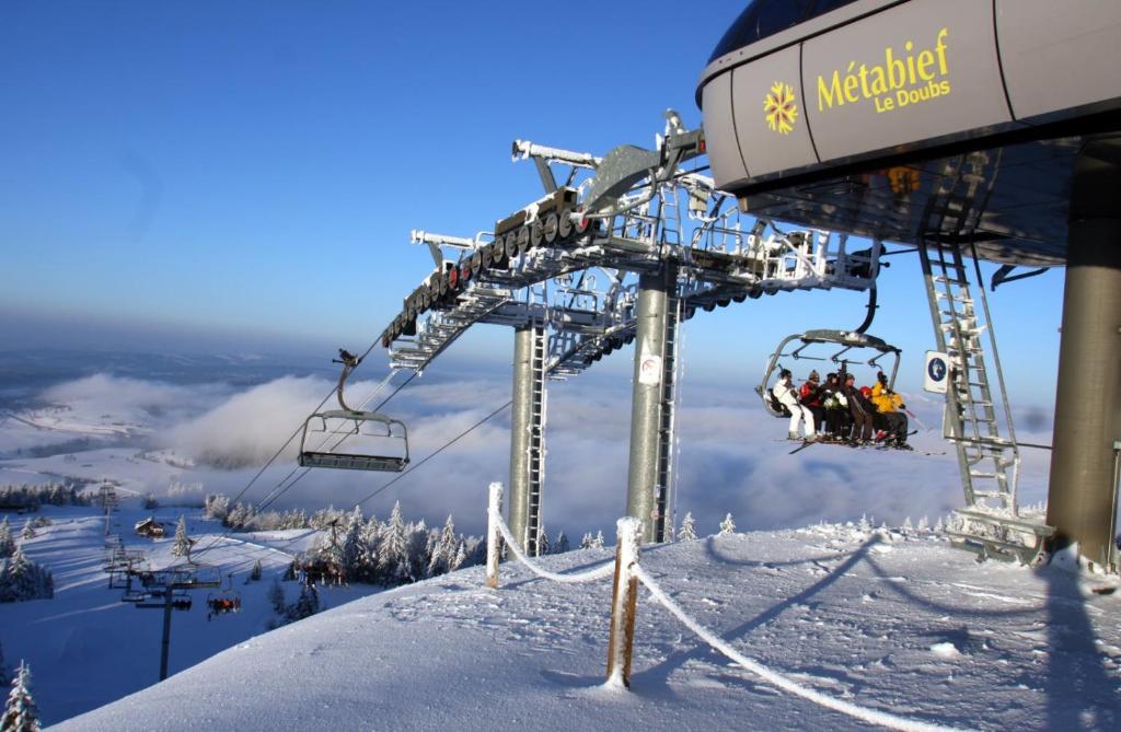 a ski lift with people on it on a snowy mountain at Au-Doux-Altic chalet romantique avec JACUZZI ET SAUNA in Métabief