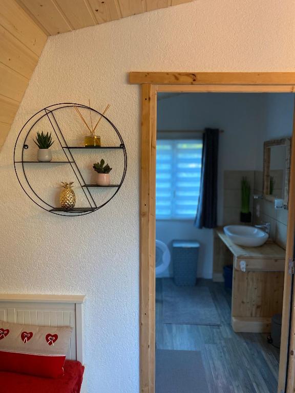 a bathroom with a sink and a toilet and a mirror at Au-Doux-Altic chalet romantique avec JACUZZI ET SAUNA in Métabief