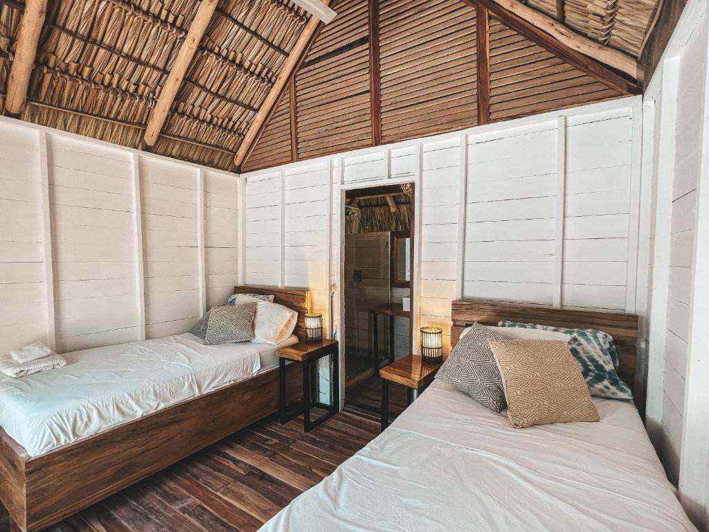 1 Schlafzimmer mit 2 Betten in einem Zimmer in der Unterkunft Monoloko Lodge Popoyo in El Limón