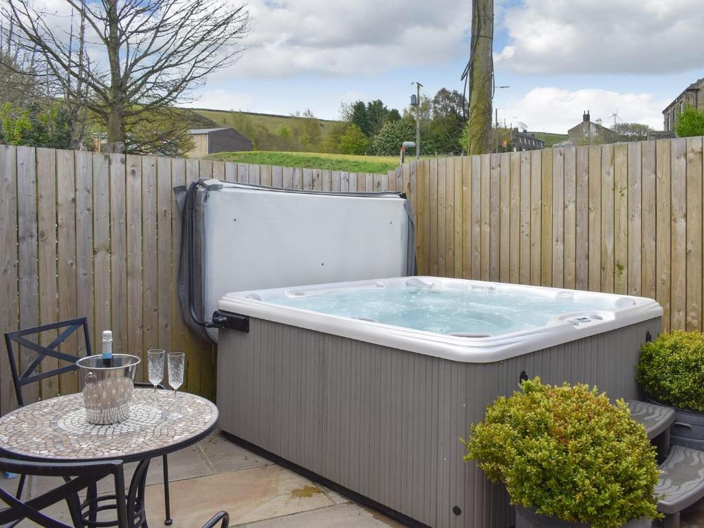 a hot tub sitting on a patio with a table at One Uk33732 in Cartworth