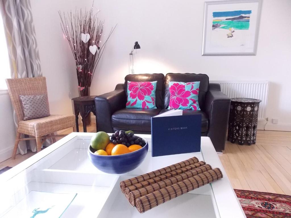 uma sala de estar com uma taça de fruta na mesa em Violet Bank Apartment Morningside em Edimburgo