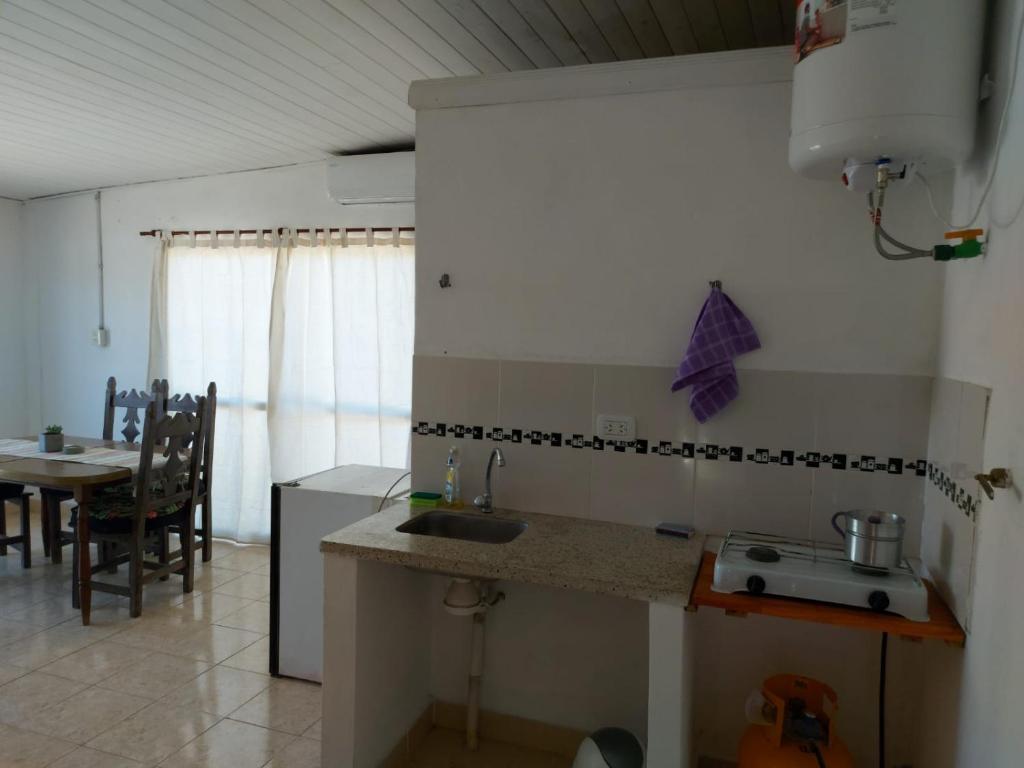 a kitchen with a sink and a table in a room at Laprida in Curuzú Cuatiá