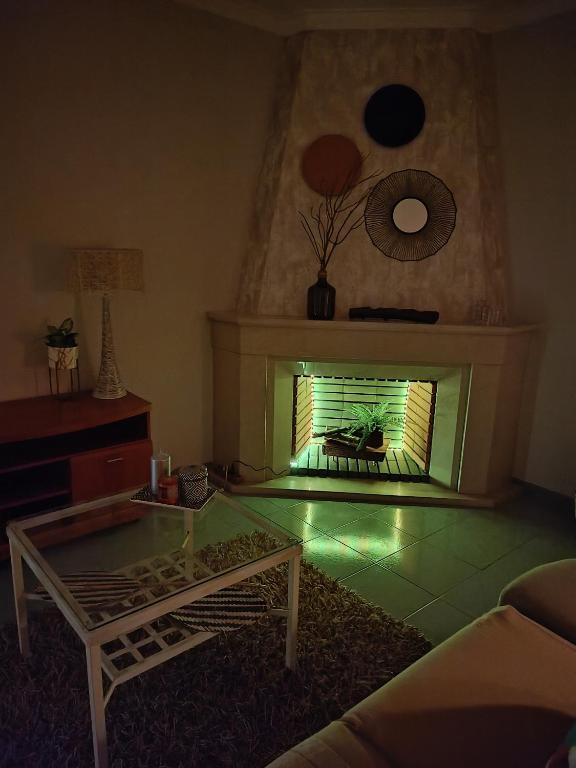 a living room with a fireplace with a table in front of it at GREEN GARDEN APARTMENT IN ODIVELAS in Odivelas