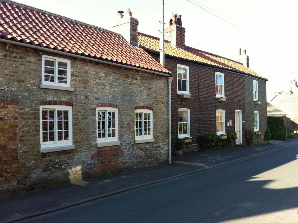 a row of brick houses with white windows on a street at Apple Loft in Hotham