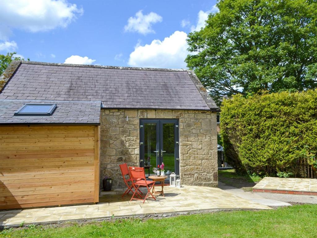 a small stone cottage with a wooden garage at The Studio At Westfield in Bellingham