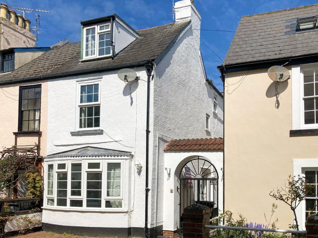 a white house with a black roof at Brook Cottage in Dawlish