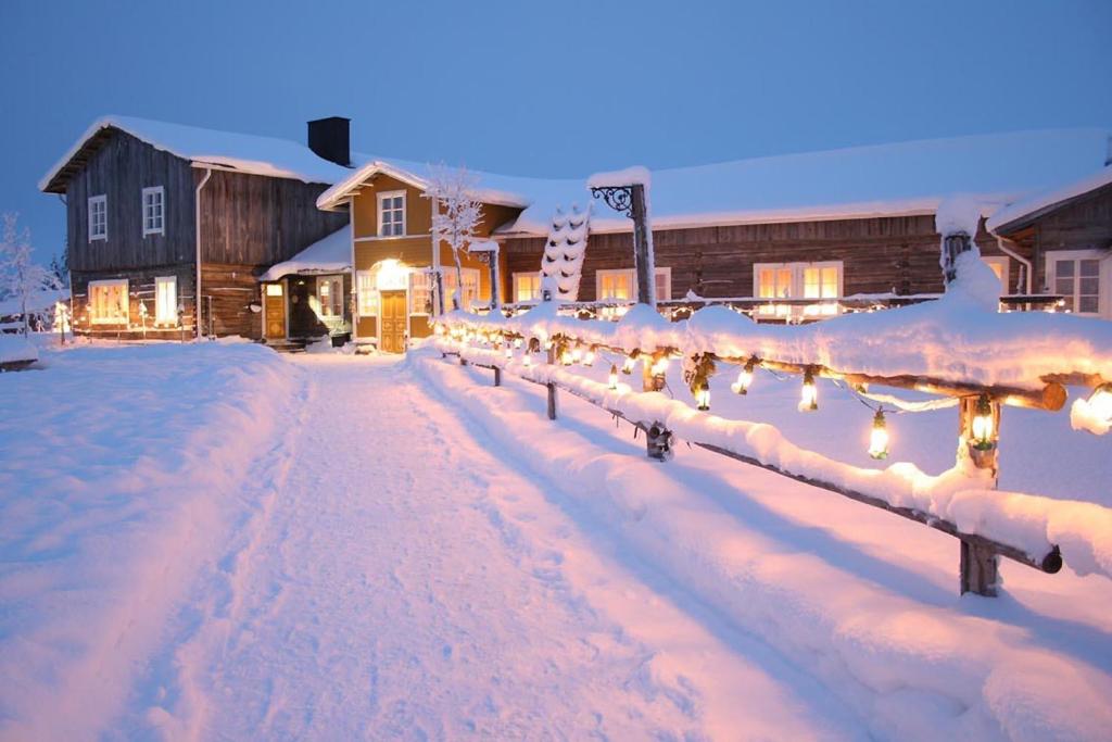 una strada ricoperta di neve con le luci di Natale di Hotel Taivaanvalkeat a Köngäs