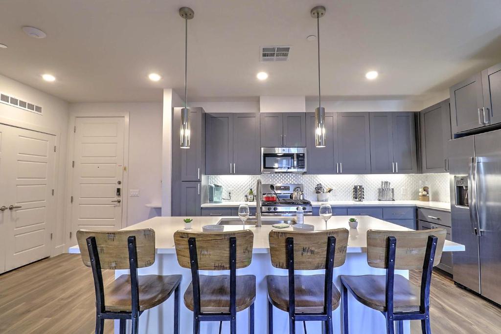 a kitchen with a large island with chairs around it at Exquisite Home-Walk Score 81-Shopping District-King Bed-Parking -G3021 in Scottsdale