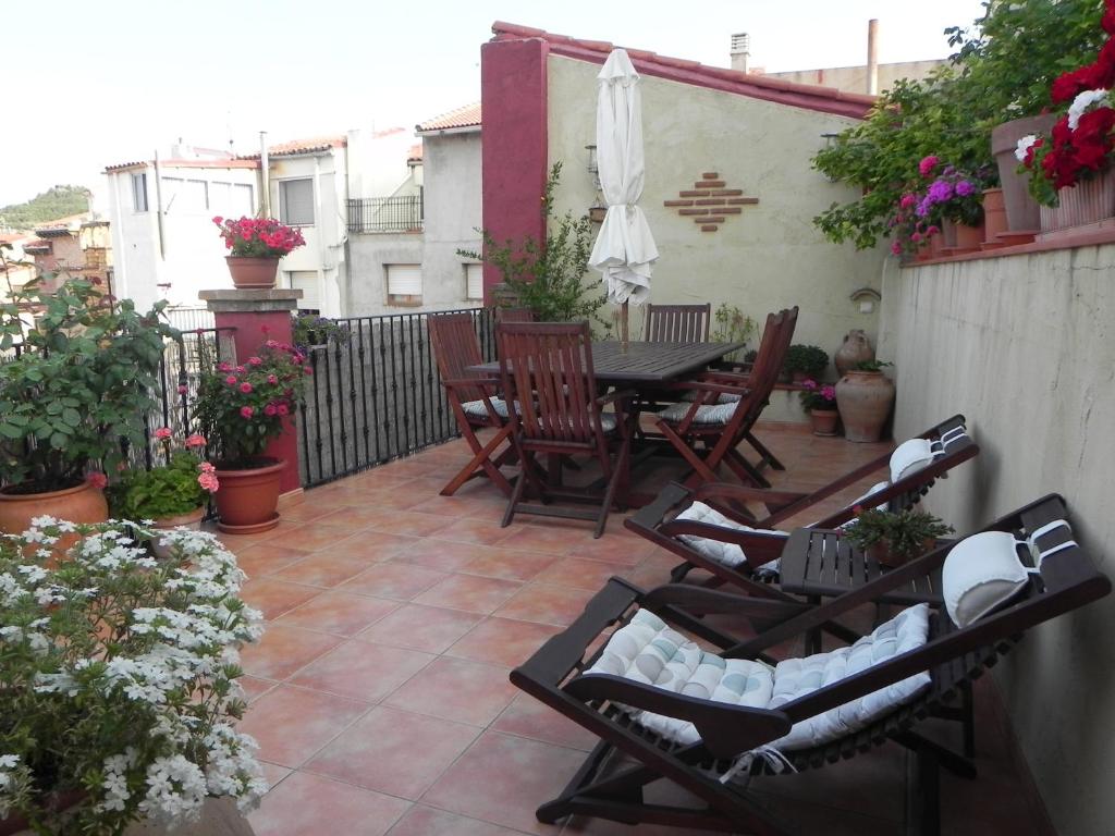 Un patio con sillas y una mesa en el balcón. en la buhardilla de mi casa, en Alcañiz