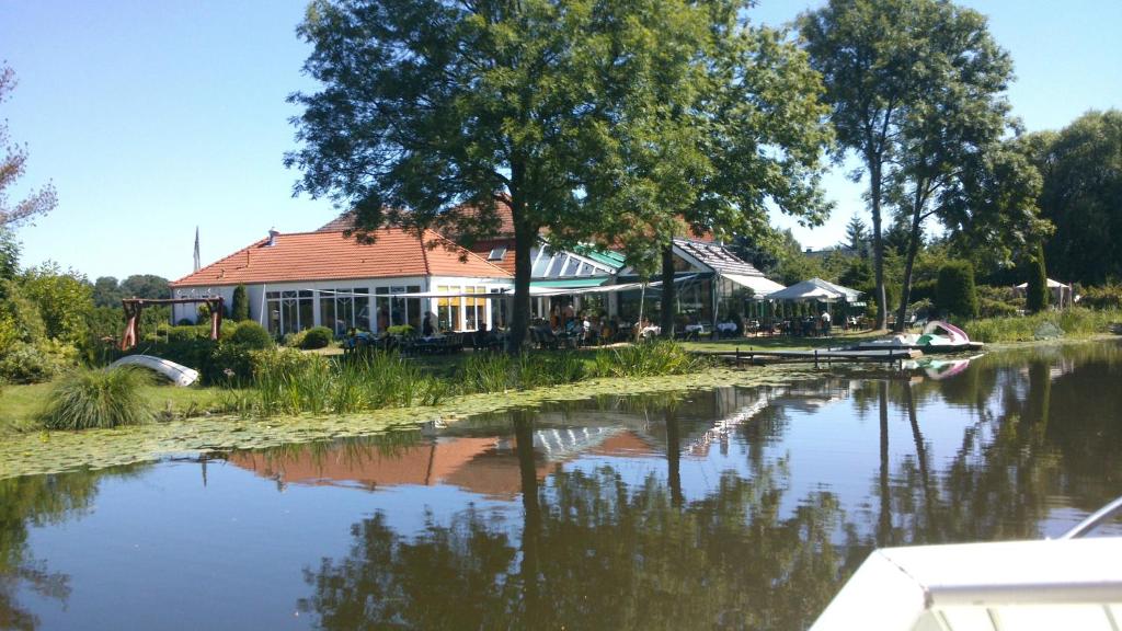 un edificio junto a un río con una casa en Hotel Grüner Baum, en Genthin