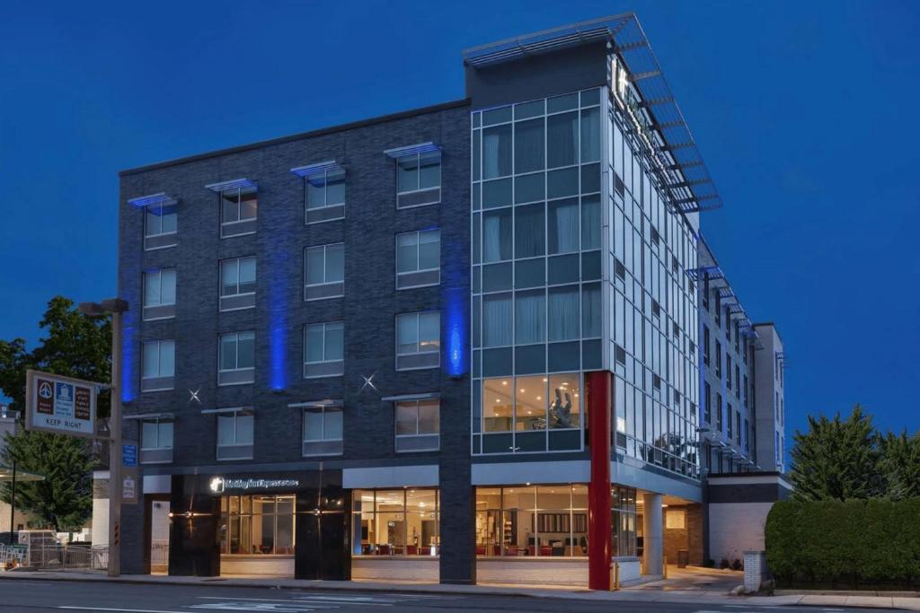 Holiday Inn Express & Suites Jersey City - Holland Tunnel, an IHG Hotel في مدينة جيرسي: مبنى عليه انوار زرقاء