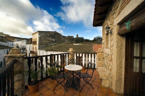 patio con mesa y sillas en el balcón en CASA RURAL MARGARITA I, en Montánchez