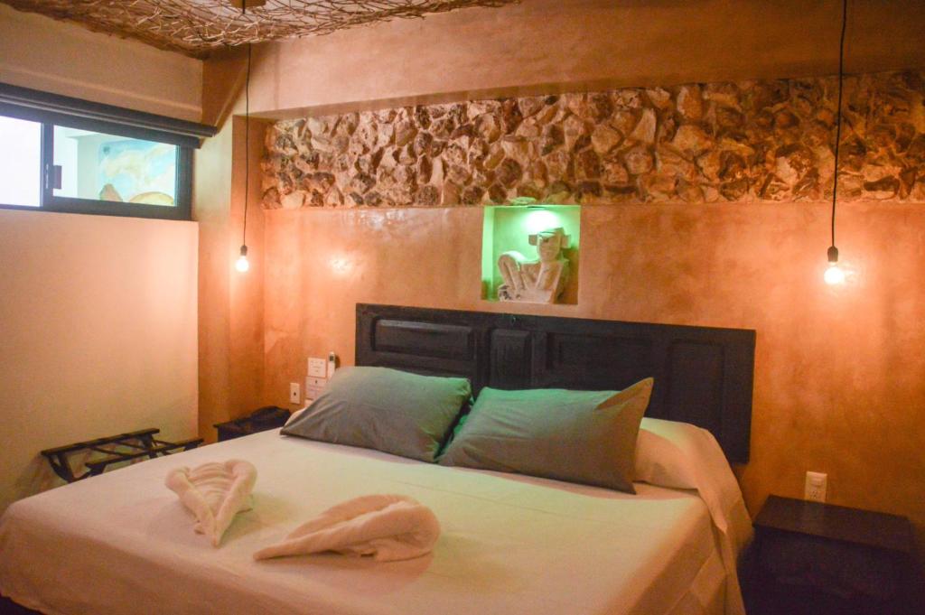 1 dormitorio con 1 cama con 2 toallas en Habitaciones Colonial Zaci, en Valladolid