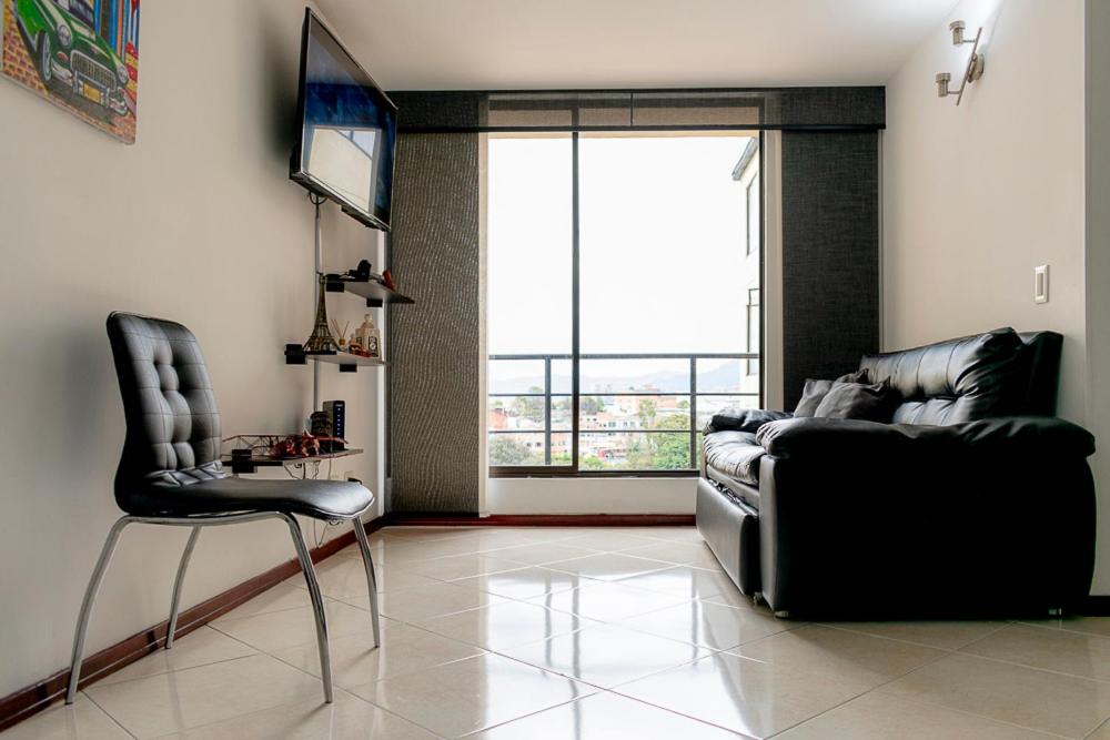 波哥大的住宿－EXPECTACULAR APARTAMENTO OPORTUNOx，带沙发、椅子和电视的客厅
