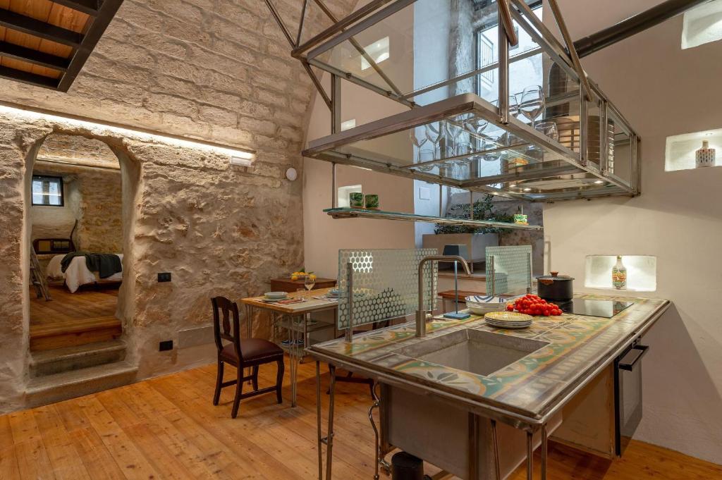 una cucina e una sala da pranzo con parete in pietra di Il Quinto Elemento - Residence Of Charme a Ostuni