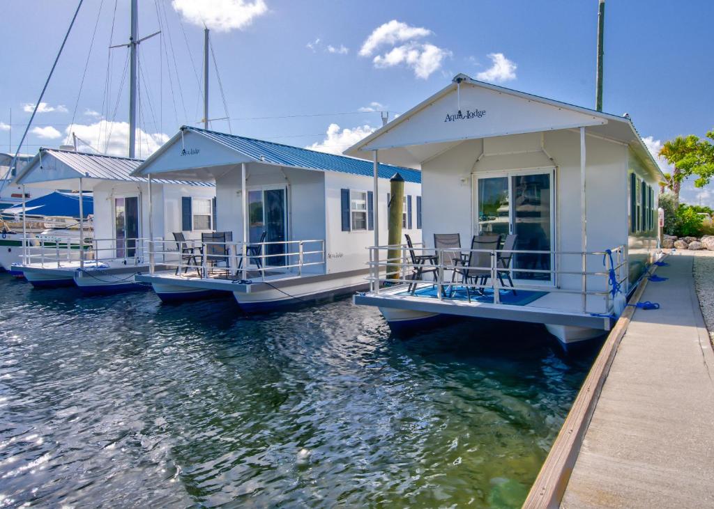 une rangée de maisons sur un quai dans l'eau dans l'établissement Aqua Lodges at Coconut Cay Rv and Marina, à Marathon