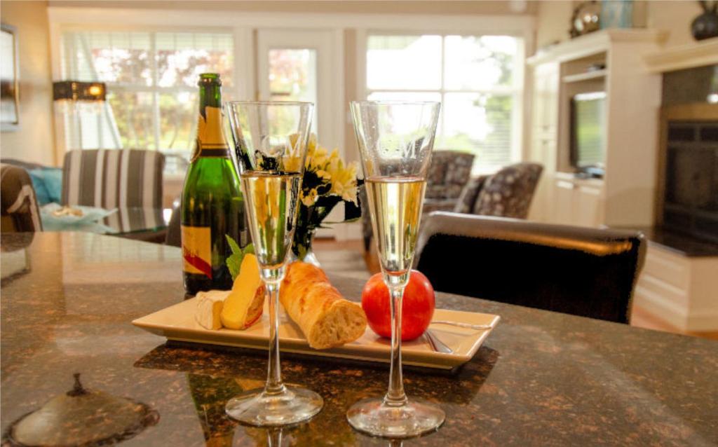 2 Gläser Champagner und Brot auf dem Tisch in der Unterkunft Crown Mansion Boutique Hotel & Villas in Qualicum Beach