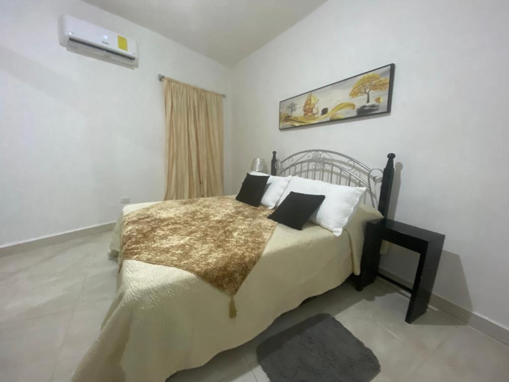 Un dormitorio con una cama grande con almohadas. en Estancia Las Mercedes, en San Felipe de Puerto Plata
