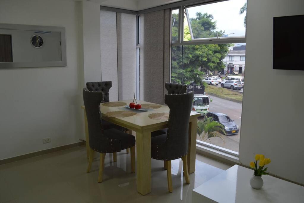 una mesa de comedor y sillas con vistas a la calle en Acogedor Apartamento, excelente ubicación. Pereira en Pereira