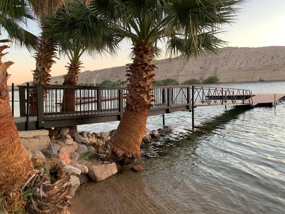 a bridge over a body of water with palm trees at #2 bedroom cozy SUITE, 1 min walk to the beach # in Bullhead City