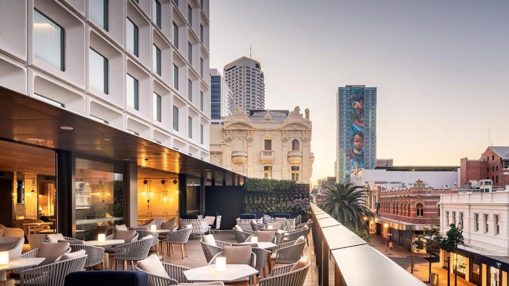 un restaurante con mesas y sillas en una calle de la ciudad en InterContinental Perth City Centre, an IHG Hotel en Perth
