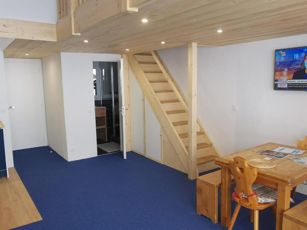 Cette chambre est dotée d'un escalier en bois et d'une table avec un sidx. dans l'établissement Appartement rénové · Ski aux pieds · Balcon · Wifi - FR-1-346-492, à Arc 1800