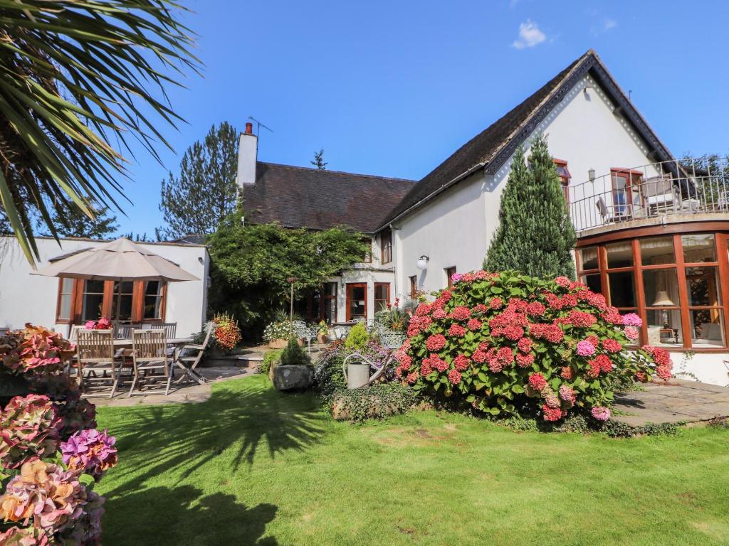 a house with a garden with flowers in the yard at Mickle Trafford Manor in Chester