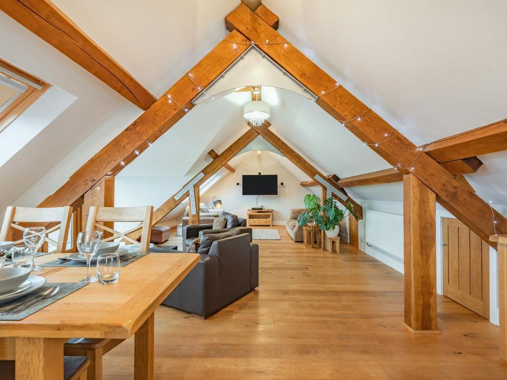 a room with a dining table and a living room at The Barn At Whitefields in Walcot