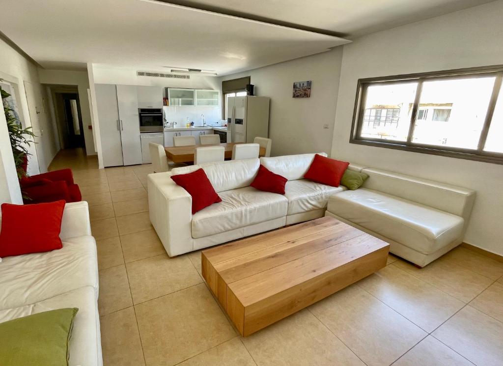 Sala de estar con 2 sofás blancos y mesa de centro en Beautiful 2-bedroom condo in the heart of Tel Aviv en Tel Aviv