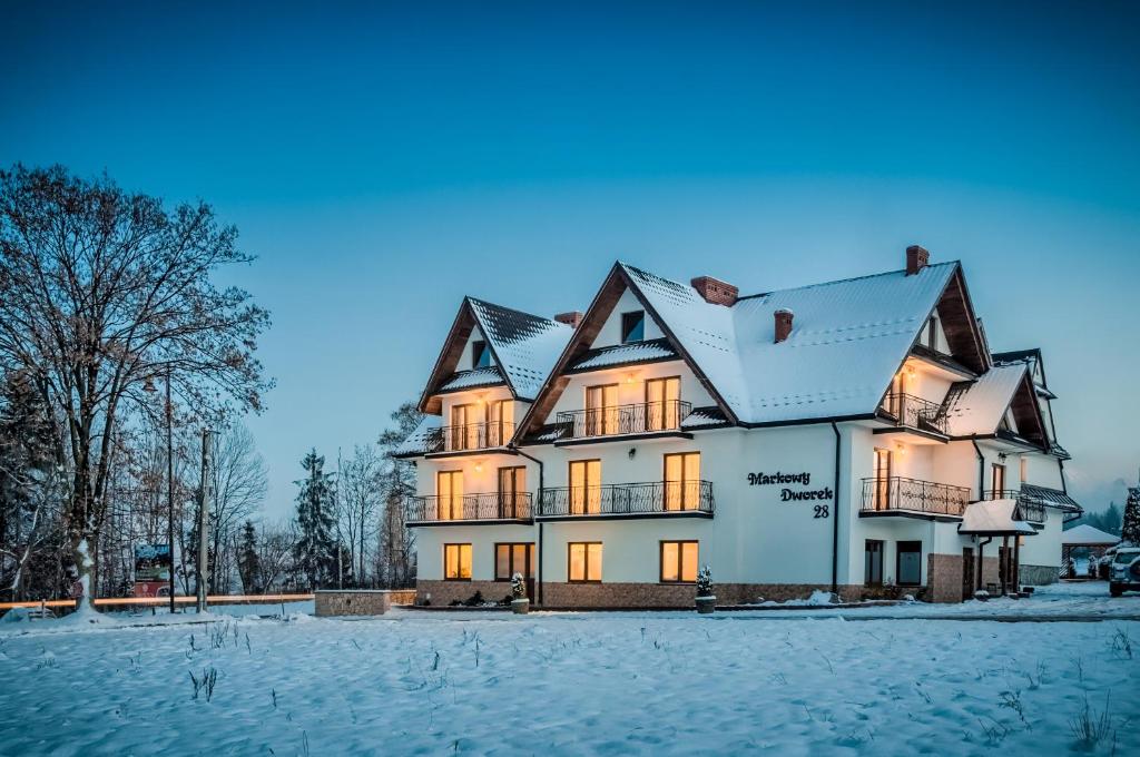 una casa grande con nieve en el suelo en Markowy Dworek, en Białka Tatrzanska