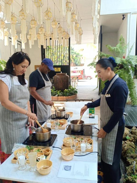A hands-on cooking activity with staff preparing food at an outdoor hotel table.