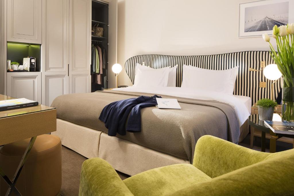 ein Hotelzimmer mit einem Bett und einem Stuhl in der Unterkunft Hôtel Le Marianne in Paris