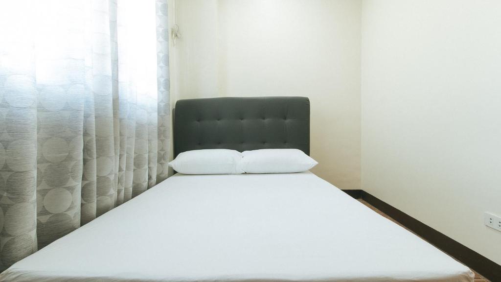 a bed with two white pillows in a bedroom at FMRR Building by RedDoorz in Manila