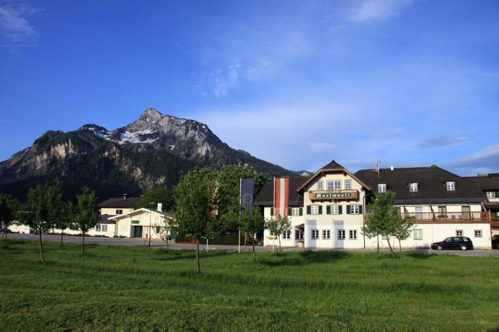 a large white building with a mountain in the background at Hotel Gasthof Mostwastl in Salzburg